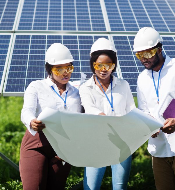 African american technician checks the maintenance of the solar panels. Group of three black engineers meeting at solar station.