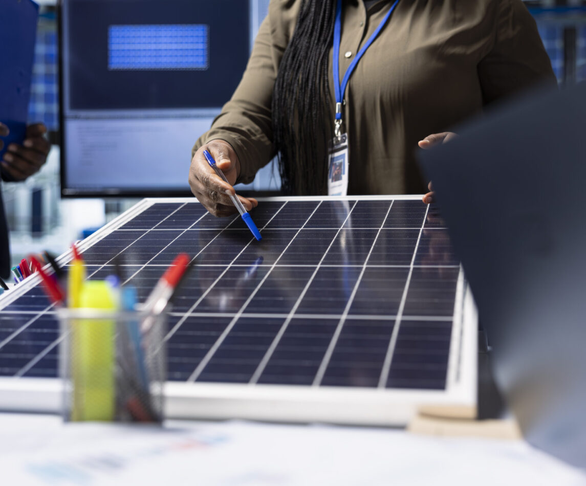 Shareholders meet with industrial plant manager to review solar panel components, analyzing material quality. Photovoltaics factory management executive presents solar panel features to investors